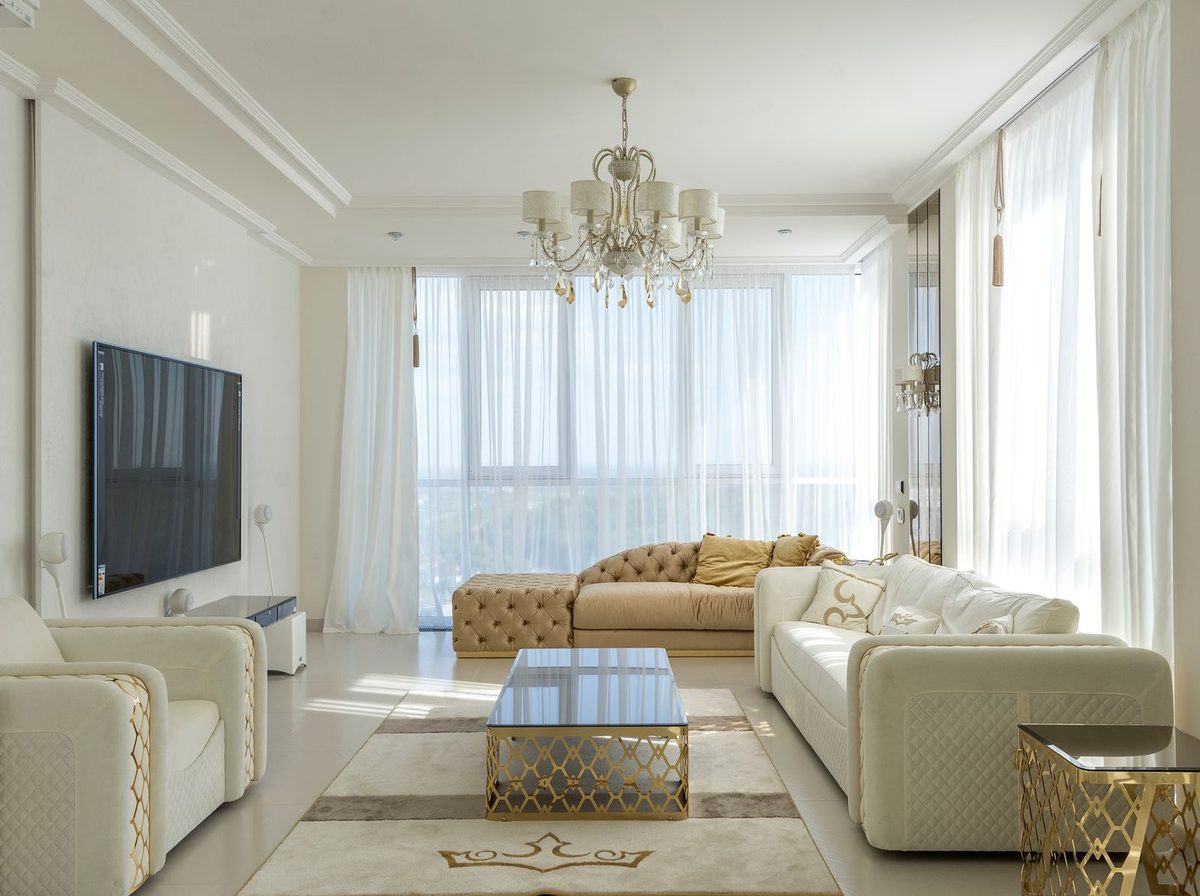 Furnished living room photographed as it is, sheer curtains drawn on the right